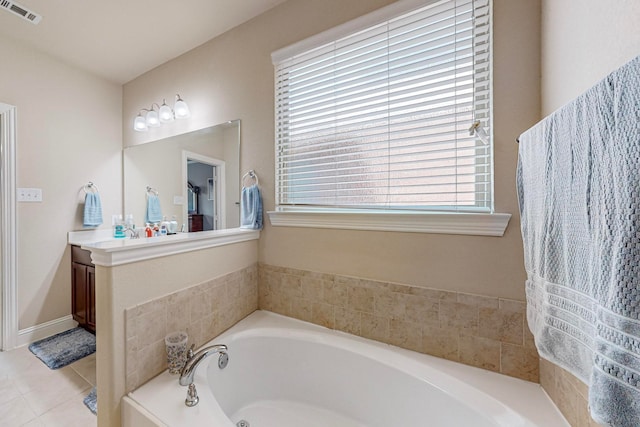 bathroom featuring tile patterned flooring, a bathing tub, and vanity