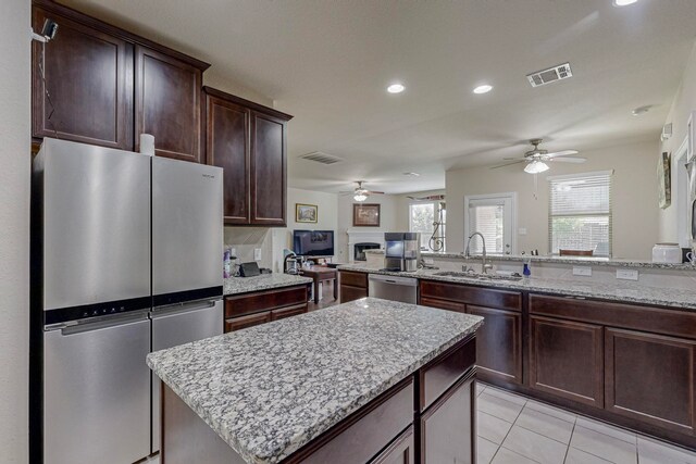 kitchen featuring appliances with stainless steel finishes, tasteful backsplash, sink, light tile patterned flooring, and ceiling fan