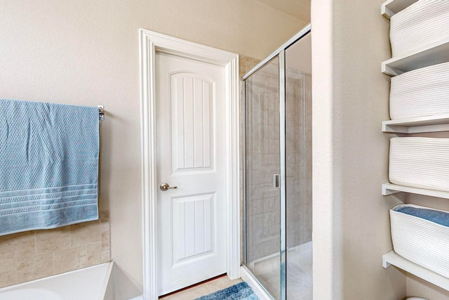 bathroom featuring a shower with door and tile patterned flooring