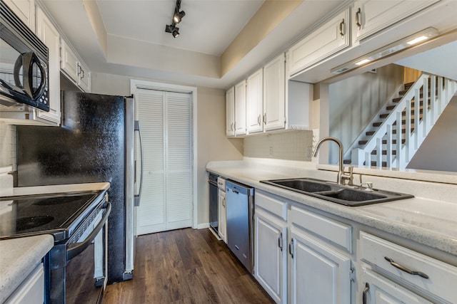 kitchen featuring white cabinets, black appliances, track lighting, sink, and a raised ceiling