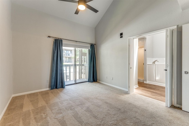 unfurnished bedroom with ceiling fan, access to exterior, light colored carpet, and high vaulted ceiling