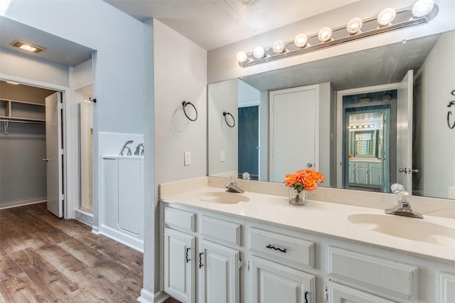 bathroom featuring an enclosed shower, vanity, and hardwood / wood-style floors