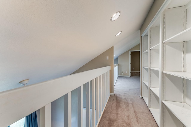 hall featuring light carpet and vaulted ceiling