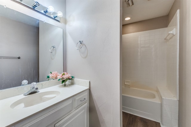 bathroom featuring tiled shower / bath, hardwood / wood-style flooring, and vanity