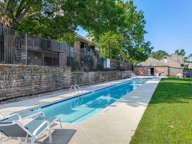 view of swimming pool with a patio area and a yard