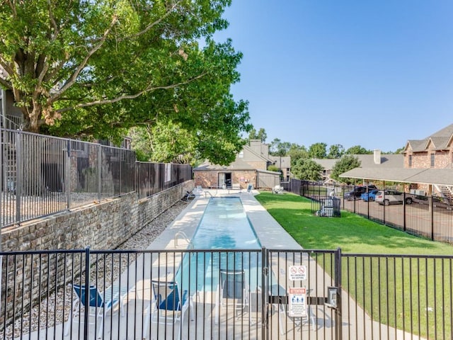 view of pool with a lawn