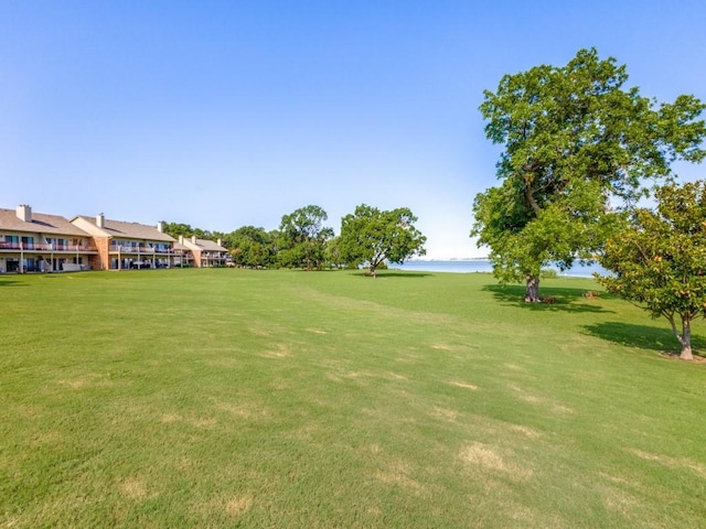 view of home's community with a water view and a yard