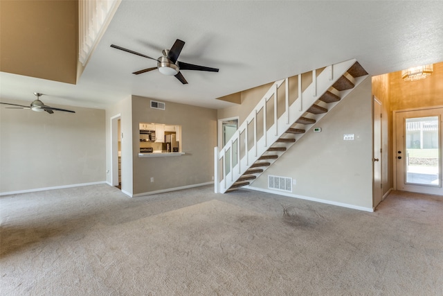 unfurnished living room with ceiling fan and light colored carpet