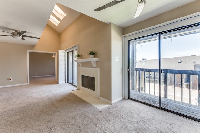 unfurnished living room with light carpet and vaulted ceiling with skylight