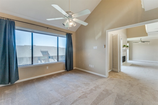 carpeted empty room with vaulted ceiling and ceiling fan