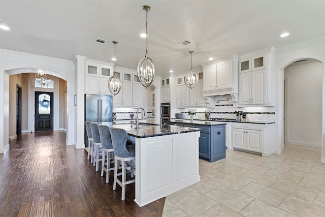 kitchen with white cabinetry, exhaust hood, stainless steel gas stovetop, and light tile patterned flooring