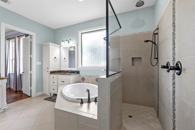 bathroom featuring vanity, tile patterned floors, and plus walk in shower