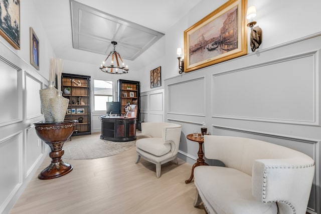 sitting room featuring light wood-type flooring and an inviting chandelier