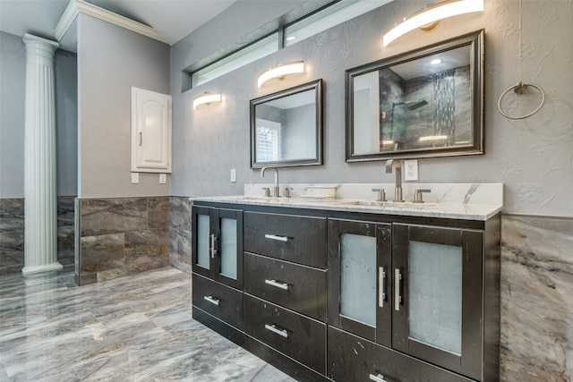 bathroom with dual bowl vanity, ornamental molding, decorative columns, and tile floors