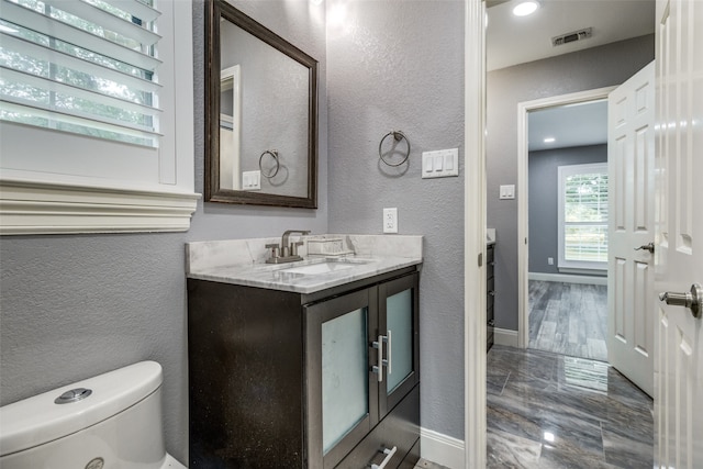 bathroom featuring tile floors, oversized vanity, and toilet