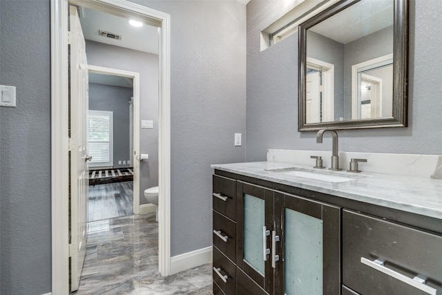 bathroom with hardwood / wood-style floors, toilet, and vanity