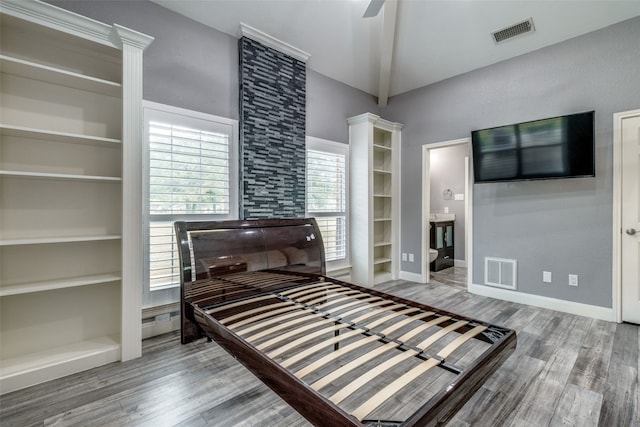 bedroom featuring beamed ceiling, ceiling fan, connected bathroom, and wood-type flooring