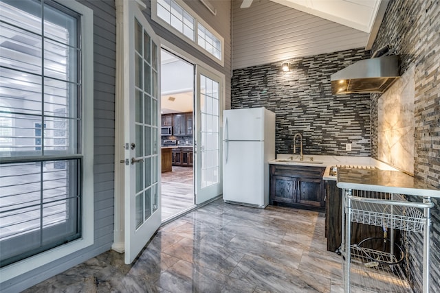 kitchen with range hood, french doors, white refrigerator, tile floors, and sink