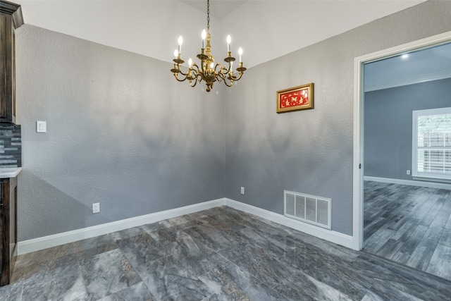 unfurnished dining area featuring an inviting chandelier and dark tile floors