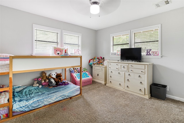 carpeted bedroom featuring ceiling fan and multiple windows