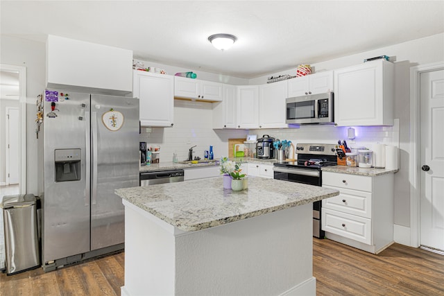 kitchen featuring appliances with stainless steel finishes, backsplash, a kitchen island, and dark hardwood / wood-style floors