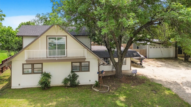 view of front of property with a garage, a balcony, and a front yard