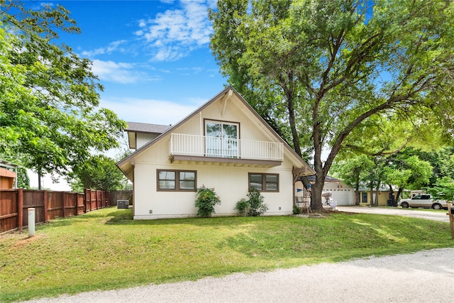 view of front of property featuring a balcony and a front yard