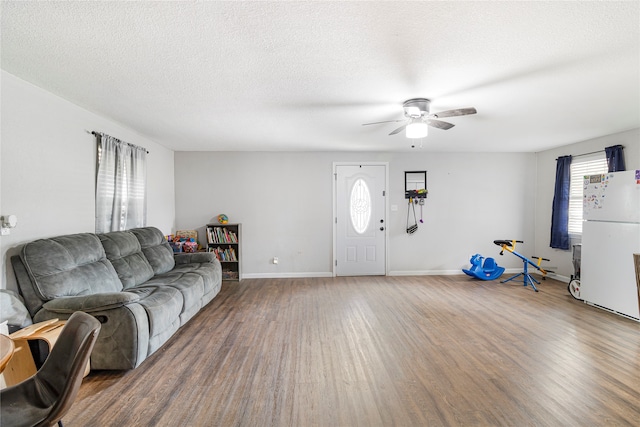 living room with wood-type flooring, ceiling fan, and a textured ceiling