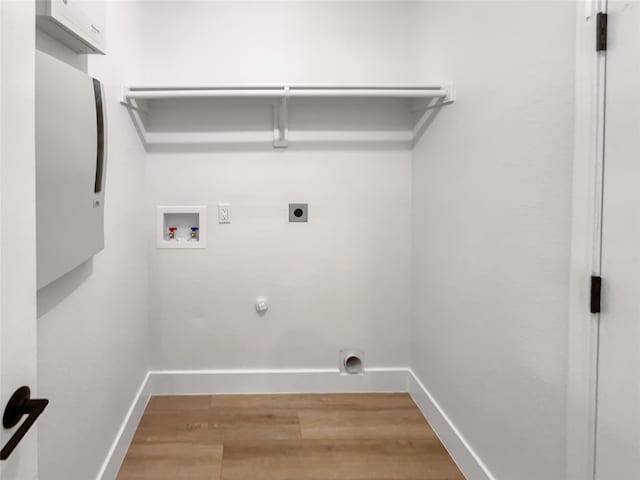 clothes washing area with hookup for a washing machine, gas dryer hookup, hardwood / wood-style floors, and electric dryer hookup