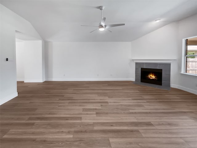 unfurnished living room with ceiling fan, hardwood / wood-style flooring, a fireplace, and lofted ceiling