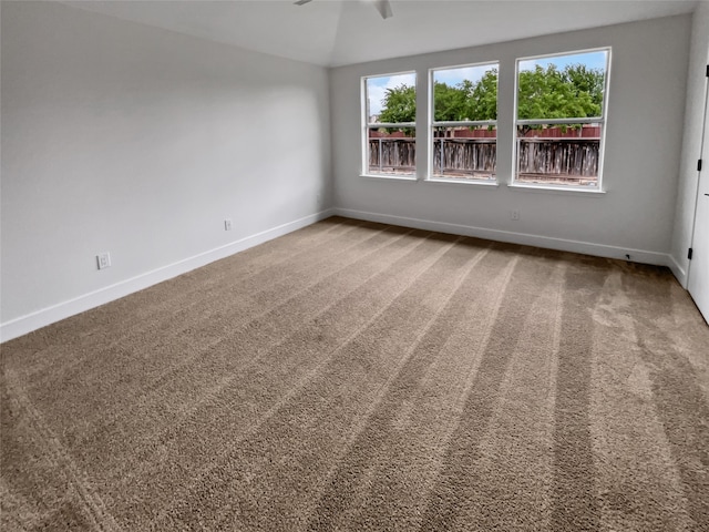 carpeted spare room with lofted ceiling