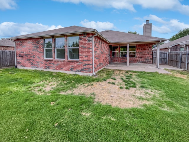 rear view of property with a yard and a patio