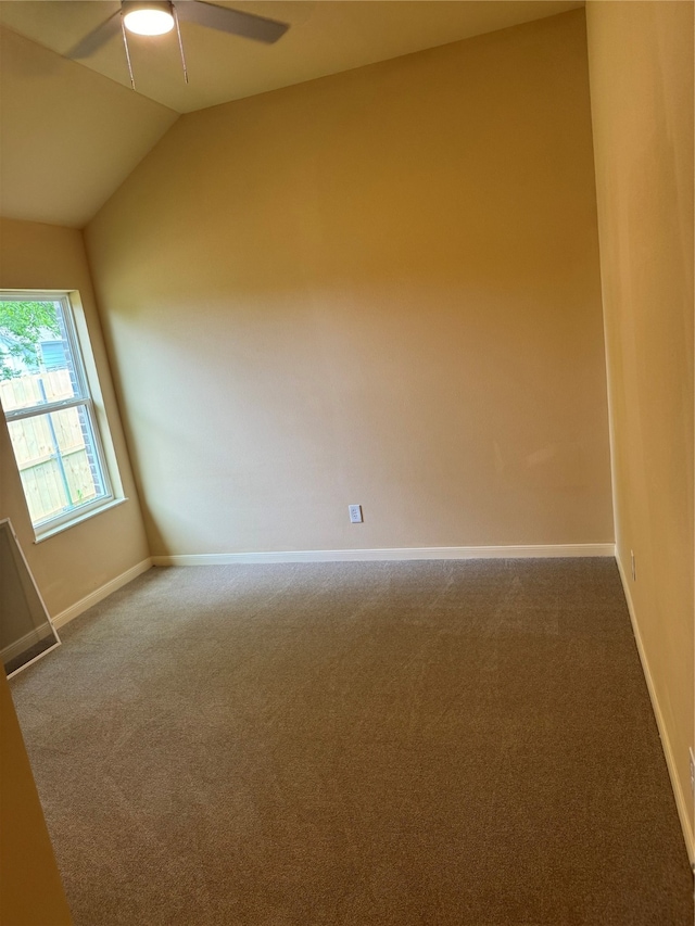 carpeted spare room featuring ceiling fan and vaulted ceiling