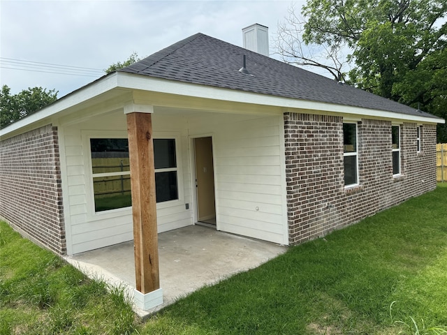 rear view of property with a yard and a patio area