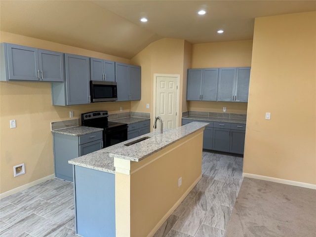 kitchen featuring light stone countertops, light carpet, electric stove, sink, and a kitchen island with sink