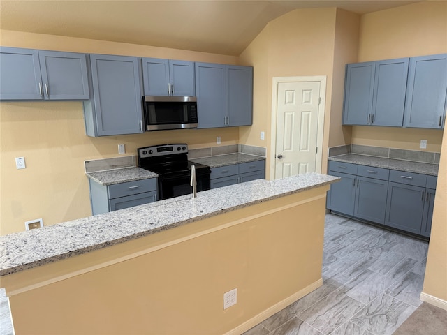 kitchen featuring stainless steel appliances, light stone countertops, blue cabinets, and lofted ceiling