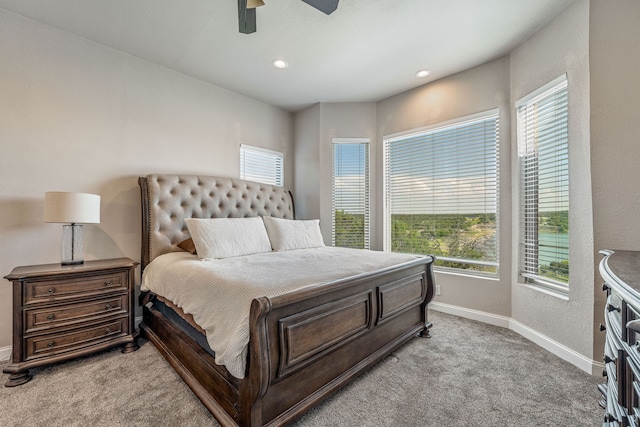 carpeted bedroom featuring ceiling fan and multiple windows