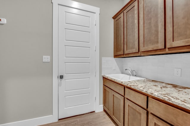 washroom with light hardwood / wood-style flooring and sink