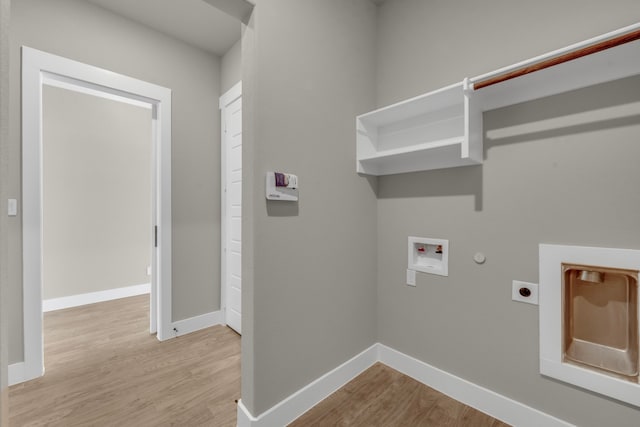 clothes washing area featuring hookup for an electric dryer, hookup for a gas dryer, washer hookup, and light hardwood / wood-style flooring