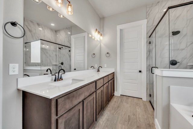 bathroom with walk in shower, vanity, and hardwood / wood-style flooring