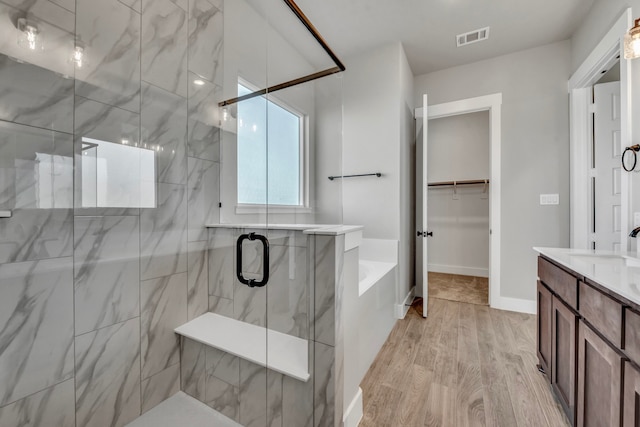 bathroom with vanity, wood-type flooring, and separate shower and tub