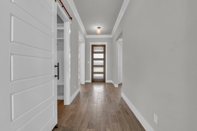 doorway to outside featuring a barn door, wood-type flooring, and crown molding