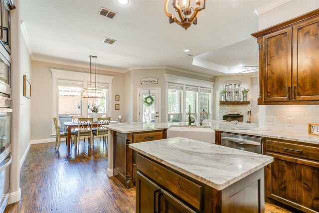 kitchen featuring a fireplace, plenty of natural light, a chandelier, and a center island