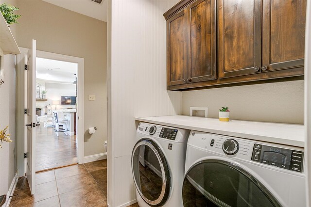 laundry area featuring cabinets, washing machine and dryer, and light tile patterned flooring