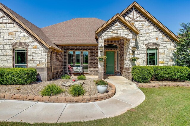 french country style house featuring a front yard