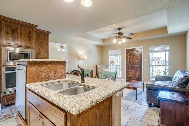 kitchen with ceiling fan, a kitchen island with sink, plenty of natural light, and sink