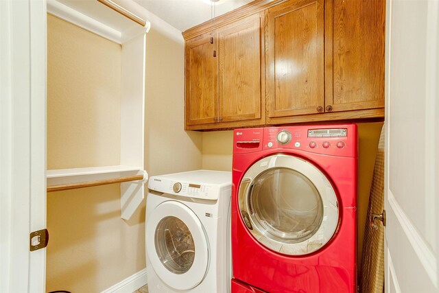 laundry room with separate washer and dryer and cabinets