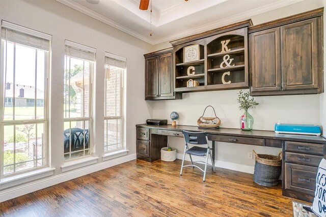 home office with wood-type flooring, built in desk, ceiling fan, and crown molding