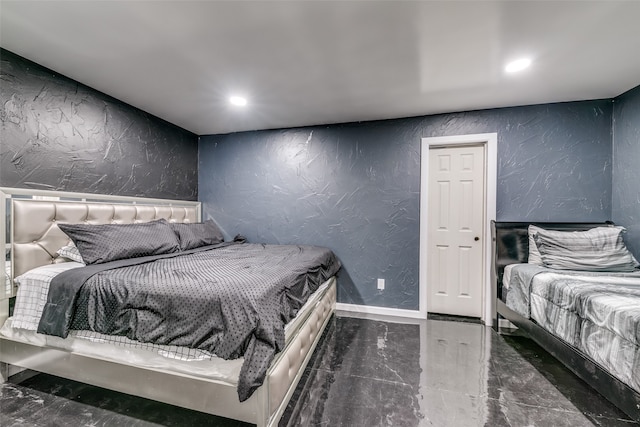 bedroom with marble finish floor, recessed lighting, and a textured wall