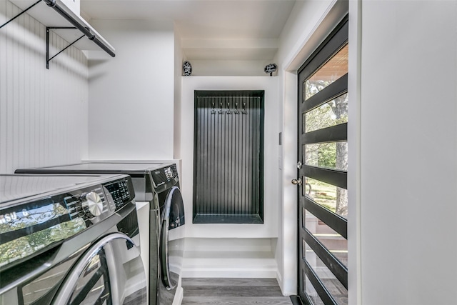 laundry area with laundry area, baseboards, washing machine and clothes dryer, and wood finished floors